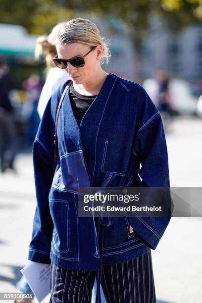 Guest wears a blue kimono denim jacket, outside Nina Ricci, during Paris Fashion Week Womenswear Spring/Summer 2018, on September 29, 2017 in Paris,...