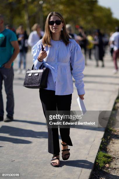 Guest wears a shirt and black pants, sandals, outside Nina Ricci, during Paris Fashion Week Womenswear Spring/Summer 2018, on September 29, 2017 in...