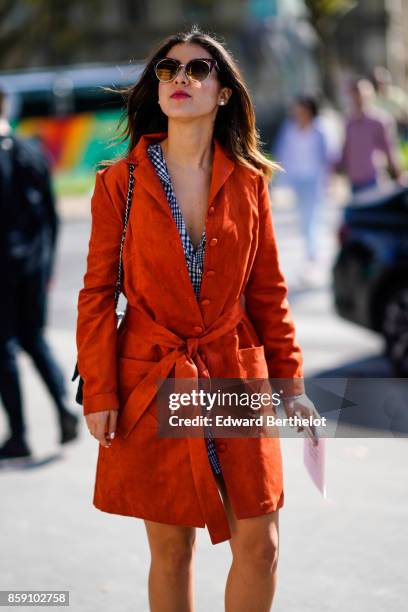 Guest wears a red coat, outside Nina Ricci, during Paris Fashion Week Womenswear Spring/Summer 2018, on September 29, 2017 in Paris, France.