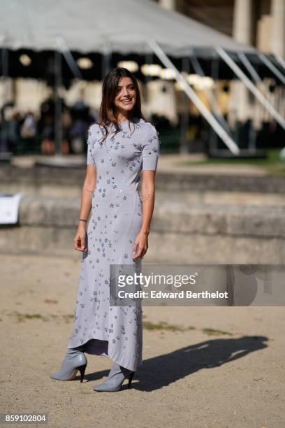 Guest wears a gray dress, outside Nina Ricci, during Paris Fashion Week Womenswear Spring/Summer 2018, on September 29, 2017 in Paris, France.