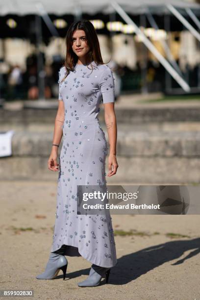 Guest wears a gray dress, outside Nina Ricci, during Paris Fashion Week Womenswear Spring/Summer 2018, on September 29, 2017 in Paris, France.