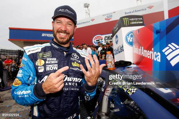 Martin Truex Jr, driver of the Auto-Owners Insurance Toyota, puts the winner's sticker on his car in Victory Lane after winning the Monster Energy...