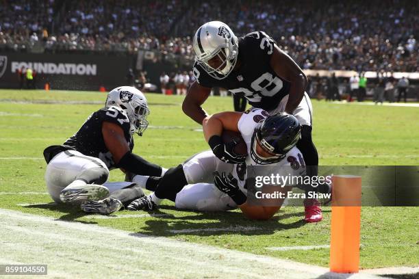 Nick Boyle of the Baltimore Ravens is stopped short of the goal line by Cory James of the Oakland Raiders during their NFL game at Oakland-Alameda...