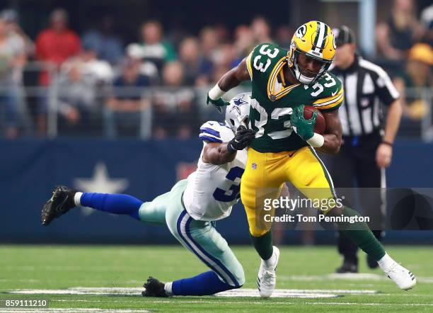 Aaron Jones of the Green Bay Packers carries the ball against Byron Jones of the Dallas Cowboys in the first half of a football game at AT&T Stadium...