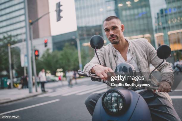 gut aussehender mann auf motorroller - moped stock-fotos und bilder