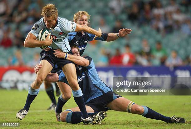 Lachlan Turner of the Waratahs is tackled during the round nine Super 14 match between the Waratahs and the Bulls at the Sydney Football Stadium on...