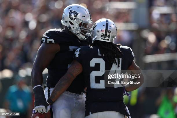 Marshawn Lynch of the Oakland Raiders celebrates with Kelechi Osemele after scoring in the third quarter against the Baltimore Ravens during their...