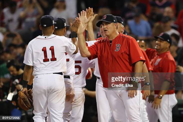 Manager John Farrell of the Boston Red Sox high fives Rafael Devers after defeating the Houston Astros 10-3 in game three of the American League...