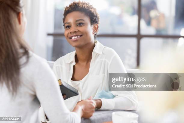 unrecognizable woman gives her friend a bible - black women in the bible stock pictures, royalty-free photos & images