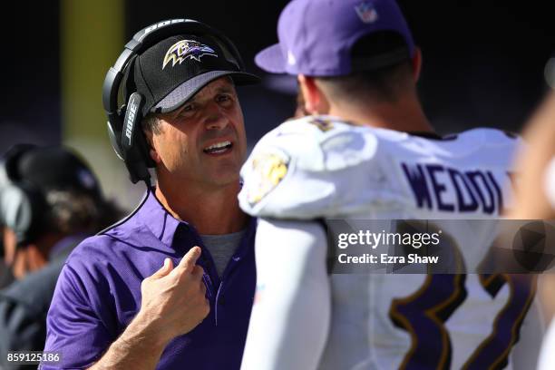 Head coach John Harbaugh of the Baltimore Ravens speaks with Eric Weddle during their NFL game against the Oakland Raiders at Oakland-Alameda County...