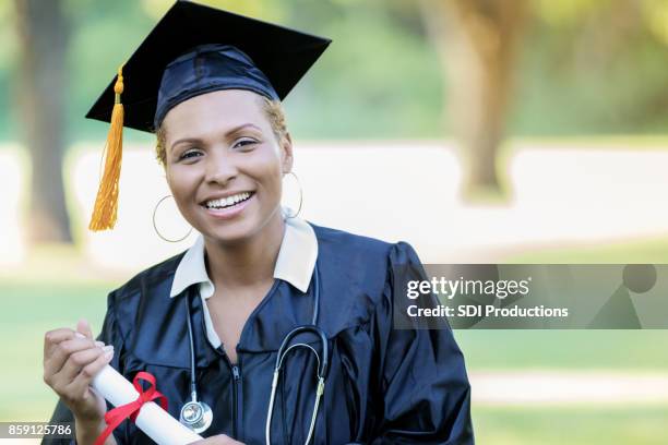 portrait of beautiful mid adult female medical school graduate - medical school graduation stock pictures, royalty-free photos & images