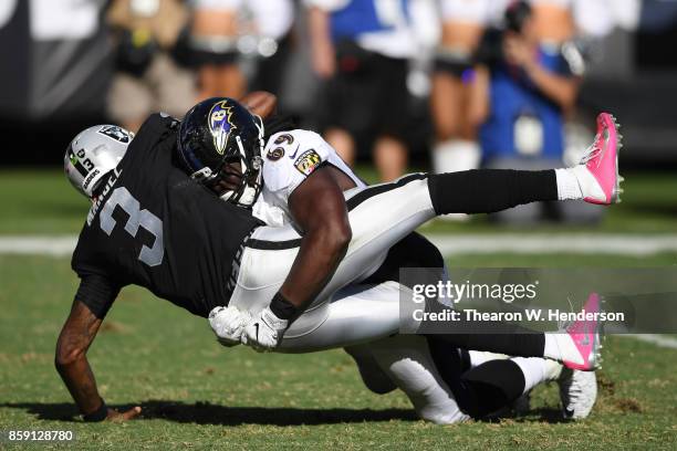 Manuel of the Oakland Raiders is hit by Willie Henry of the Baltimore Ravens during their NFL game at Oakland-Alameda County Coliseum on October 8,...