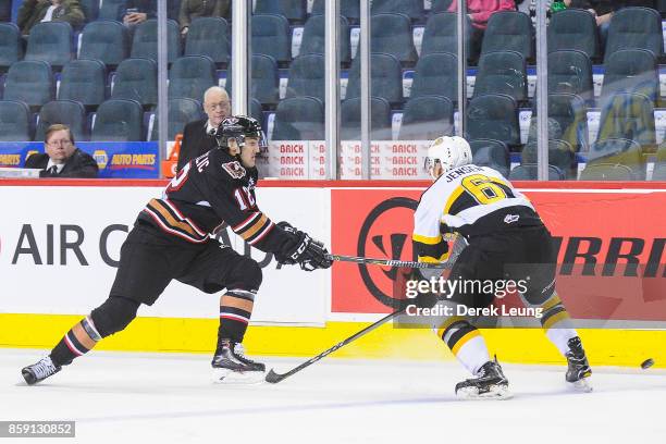 Mark Kastelic of the Calgary Hitmen chases the puck against Kade Jensen of the Brandon Wheat Kings during a WHL game at the Scotiabank Saddledome on...