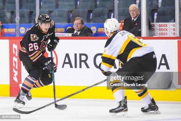 Andrew Fyten of the Calgary Hitmen skates with the puck as Kade Jensen of the Brandon Wheat Kings defends during a WHL game at the Scotiabank...
