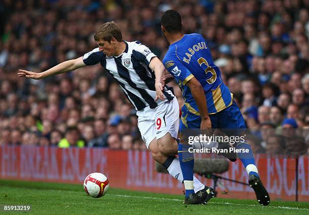 Chris Wood of West Brom is tackled by Younes Kaboul of Portsmouth during the Barclays Premier League match between Portsmouth and West Bromwich...