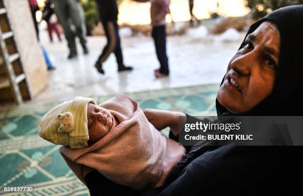 Woman, who along members of her family were used as human shields by Islamic State group fighters, holds a new born baby after fleeing from the...