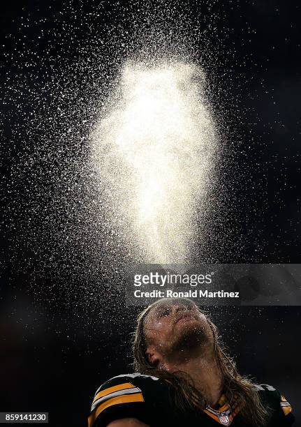 Clay Matthews of the Green Bay Packers spits water above his head during a timeout in the fourth quarter of play against the Dallas Cowboys at AT&T...