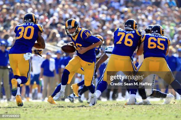 Jared Goff hands off to Todd Gurley as Rodger Saffold and John Sullivan of the Los Angeles Rams block uring the second half of a game against the...