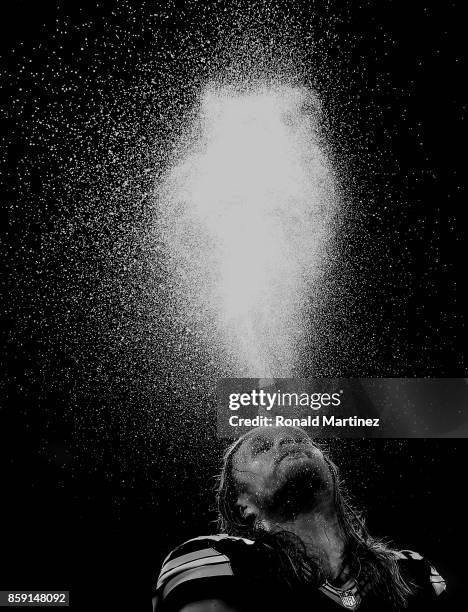 Clay Matthews of the Green Bay Packers spits water above his head during a timeout in the fourth quarter of play against the Dallas Cowboys at AT&T...