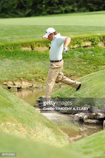 Graeme McDowell of Northern Ireland steps across the water on the thirteenth hole during the third round of the US Masters at the Augusta National...