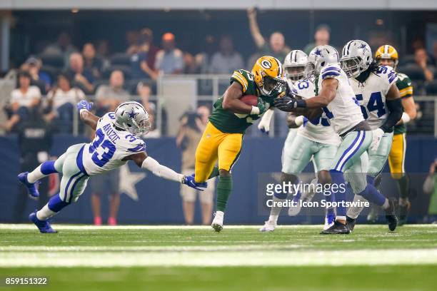Green Bay Packers running back Aaron Jones is tackled by Dallas Cowboys cornerback Chidobe Awuzie and free safety Byron Jones during the football...