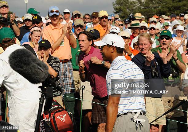 The crowd cheers as US golfer Tiger Woods walks off the course after completing the third round of the US Masters at the Augusta National Golf Club...
