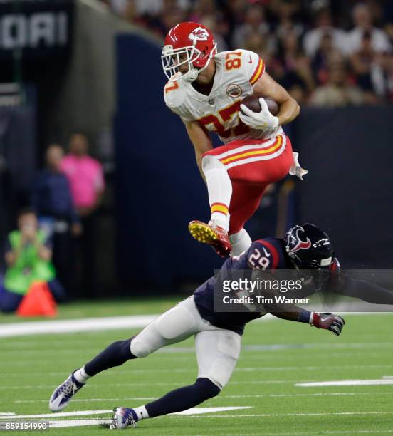 Travis Kelce of the Kansas City Chiefs hurdles Andre Hal of the Houston Texans in the second quarter at NRG Stadium on October 8, 2017 in Houston,...