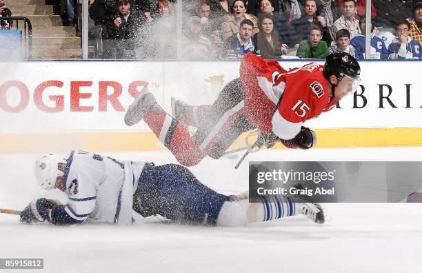 Dany Heatley of the Ottawa Senators is tripped up by Pavel Kubina of the Toronto Maple Leafs during game action April 11, 2009 at the Air Canada...