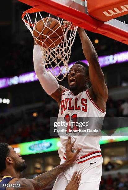 David Nwaba of the Chicago Bulls dunks over Perry Jones of the New Orleans Pelicans during a preseason game at the United Center on October 8, 2017...