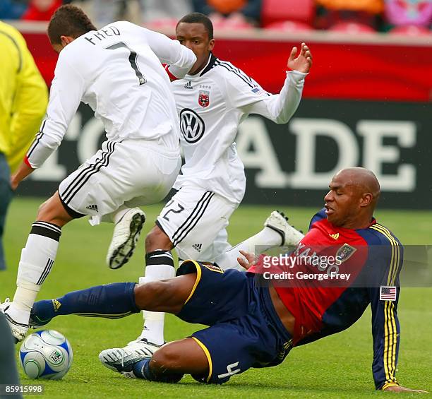 Jamison Olave of Real Salt Lake kicks the ball away from Fred of D.C. United as Rodney Wallace looks on during the first half of MLS action at Rio...