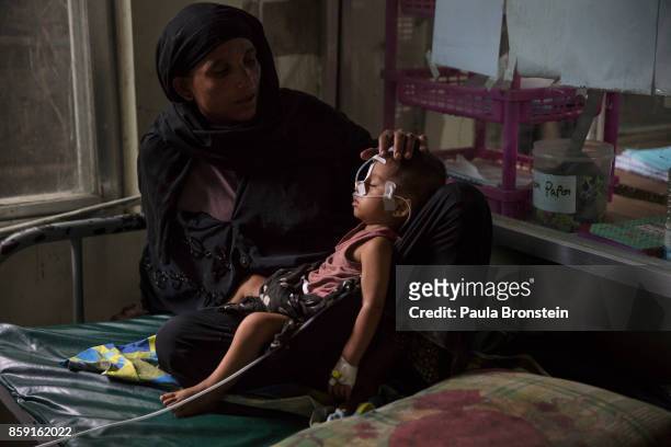 Amina holds her son, Hatea Ullah after being fed through a feeding tube in the pediatric - neonatal unit at the 'Doctors Without Borders' Kutupalong...