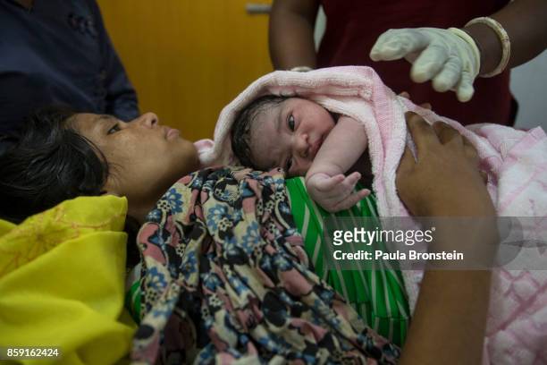 Asma holds her newborn baby girl in the birthing unit at the 'Doctors Without Borders' Kutupalong clinic on October 3, 2017 in Cox's Bazar,...