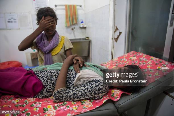 Kajal Nur is treated for injuries from a road traffic accident as her friend tries to comfort her at the 'Doctors Without Borders' Kutupalong clinic...
