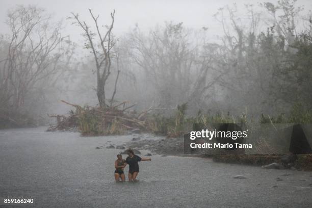 People cross the Espiritu Santo river during heavy afternoon rains more than two weeks after Hurricane Maria hit the island, on October 8, 2017 in...