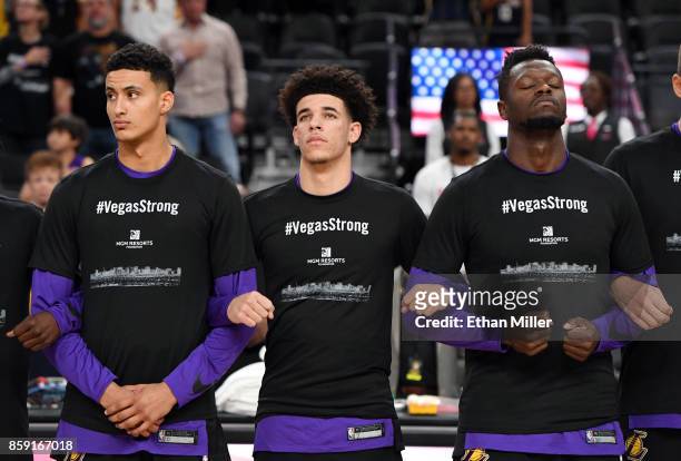 Kyle Kuzma, Lonzo Ball and Julius Randle of the Los Angeles Lakers wear #VegasStrong T-shirts as they lock arms during a moment of silence held to...