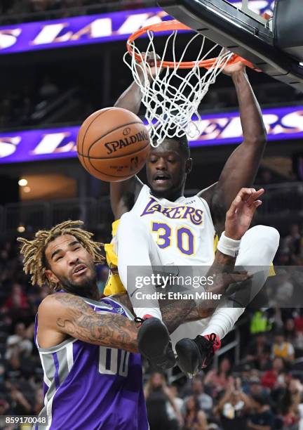 Julius Randle of the Los Angeles Lakers dunks against Willie Cauley-Stein of the Sacramento Kings during their preseason game at T-Mobile Arena on...
