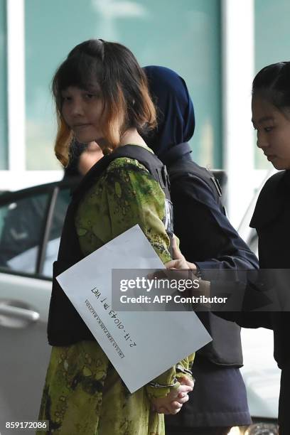 Vietnamese defendant Doan Thi Huong is escorted by police personnel as she arrives at the Malaysian Chemistry Department in Petaling Jaya, outside...