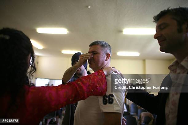The hands of Aliss and Rob Cresswell treat a man with a nasal problem during the Cafe Life Easter Sunday Miracle Service on the Blacon estate on...
