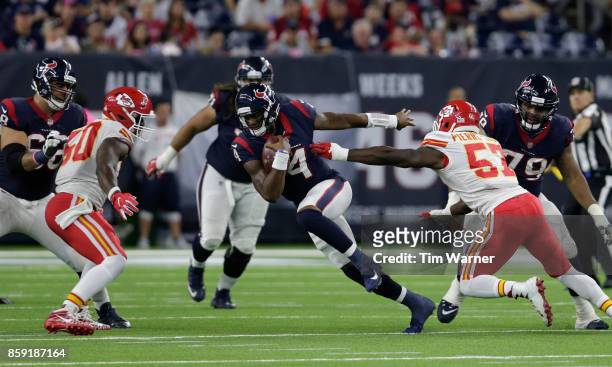 Deshaun Watson of the Houston Texans scrambles between Kevin Pierre-Louis of the Kansas City Chiefs and Justin Houston in the fourth quarter at NRG...