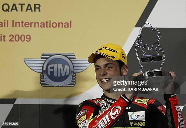 Germany's Sandro Cortese celebrates on the podium after finishing third in the 125cc race at the Qatar Grand Prix in Doha on April 12, 2009. Italy's...