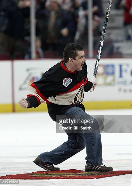 Nick Nicholson celebrates after winning 100,000 dollars by shooting the puck through a hole and into the net on April 12, 2009 at the United Center...