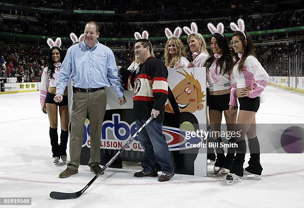 Nick Nicholson celebrates after winning 100,000 dollars in a contest sponsored by Gerber Collision and Glass by shooting the puck through a hole and...