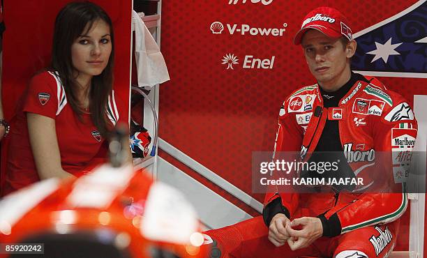 MotoGP rider Casey Stoner of Australia and his wife Adriana wait inside the pit lane under heavy rain after the Grand Prix of Qatar was stopped at...