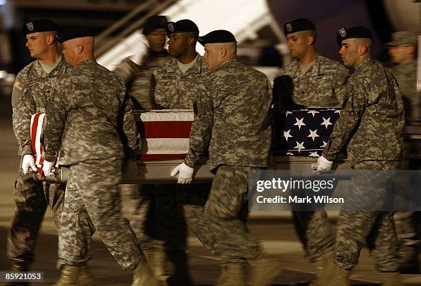 Members of a U.S. Army carry team transport a flag-draped transfer case holding the remains of Army Staff Sergeant Bryan E. Hall, during a dignified...