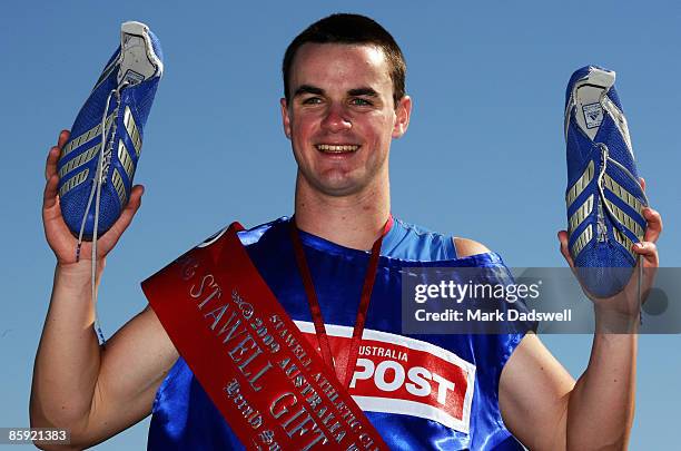 Aaron Stubbs of QLD celebrates whilst holding the pair of running spikes sent to him by Matt Shirvington after winning the 2009 Stawell Easter Gift...
