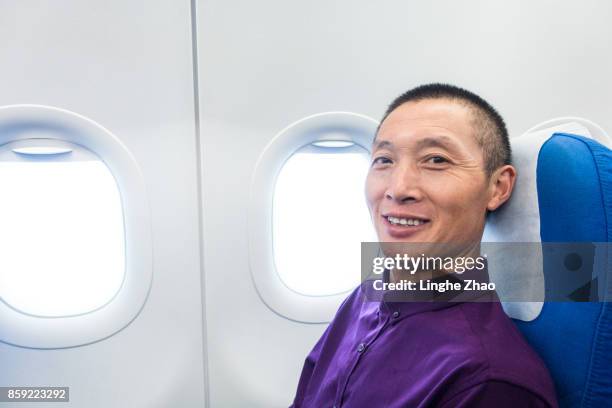 asian man smiling at airplane - linghe zhao photos et images de collection