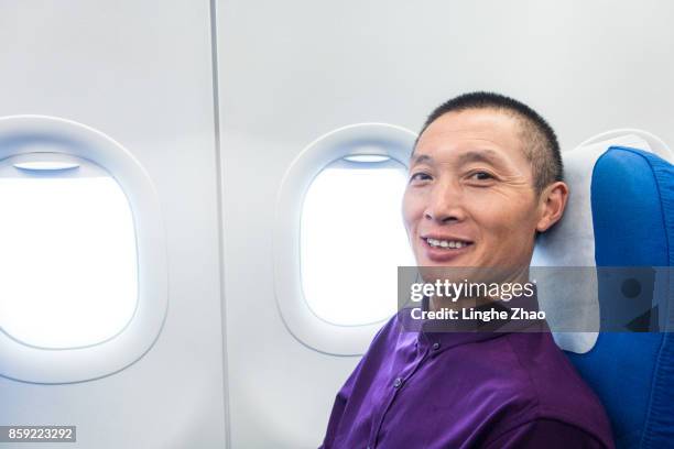 asian man smiling at airplane - linghe zhao stock pictures, royalty-free photos & images