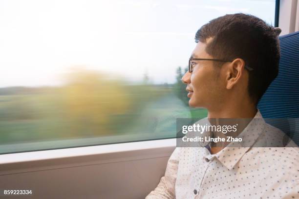 man looking out of train window - linghe zhao stock pictures, royalty-free photos & images