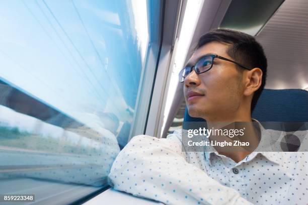 man looking out of train window - linghe zhao stock pictures, royalty-free photos & images