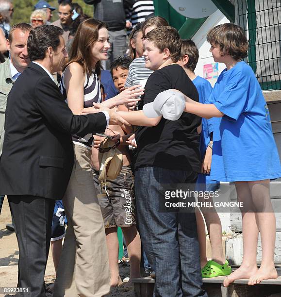 French President Nicolas Sarkozy and wife, First Lady Carla Bruni-Sarkozy are greeted by children before attending the trophy ceremony of the first...